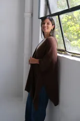 Poncho abierto de color marrón chocolate, con diseño de corte asimétrico, mangas amplias y bolsillos frontales aplicados.