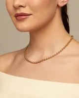 Collar de cadena formado por esferas continuas, con cierre de mosquetón y cadena de extensión. Está fabricado en una aleación de metales con baño de oro de 18k.