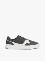 Zapatillas de tenis Tommy Hilfiger de corte bajo, confeccionadas en ante color gris con paneles en contraste de color blanco. Presentan cierre con cordones, suela de goma blanca y logo de la marca grabado en el lateral y el talón.