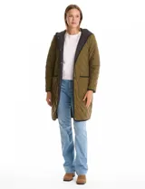 Campera reversible de corte largo con diseño capitoneado. Un lado presenta un tono verde oliva y el otro un tono negro, ambos con cierre frontal mediante botones a presión y bolsillos laterales.