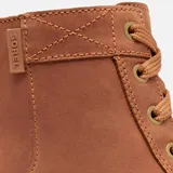 Bota de caña media Sorel, confeccionada en piel impermeable color marrón tostado. Presenta cierre de cordones con ojales metálicos, tirador en el talón y una suela robusta de caucho moldeado con diseño dentado.