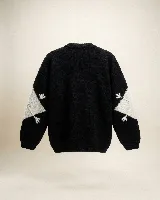 Buzo tejido a mano con diseño de rombos en contraste blanco y negro, cuello redondo y mangas largas.