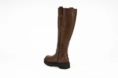 Bota de caña alta confeccionada en cuero nobuck color marrón, con suela track dentada y detalle de tirador en la parte superior de la caña.
