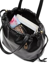 Bolso tipo tote color negro de cuero sintético ultrasuave, con silueta relajada, cordón ajustable en la parte superior y asas superiores.