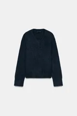 Jersey de punto con mezcla de lana y alpaca, color amarillo mostaza, con cuello en pico y manga larga. Presenta acabados en rib en puños y bajo.