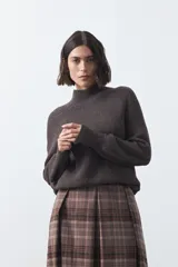 Polera de tejido de punto en color marrón oscuro, con cuello alto y diseño de silueta relajada.