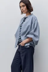 Pantalón jean de tiro alto con calce straight y pierna recta, confeccionado en denim de aspecto limpio. Cuenta con cinco bolsillos, cierre frontal con botón y presillas para cinturón.
