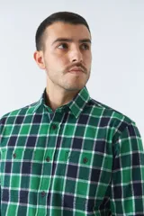 Camisa de viyela a cuadros negros, blancos y rojos, de corte slim fit, con bolsillos en el pecho, manga larga y cierre con botones.