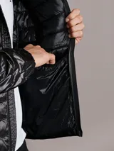 Campera acolchada Calvin Klein con capucha, cierre frontal con cremallera y bolsillos laterales con cierre. Presenta un diseño ligero y funcional con acabado brillante.