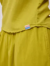 Musculosa color verde oliva, de corte recto y sin mangas, confeccionada en tejido de lino y algodón.