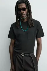 Camiseta de corte regular con cuello redondo, manga corta y bolsillo plastrón en el pecho. Presenta un acabado de color verde con efecto lavado.