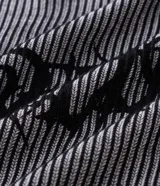 Suéter de punto con diseño de rayas verticales en tonos gris y negro, cuello redondo, manga larga y estampado frontal con la palabra Rebellion en estilo gótico.
