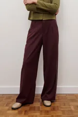 Pantalon de corte recto y pierna ancha, confeccionado en tejido tipo denim oscuro. Presenta tiro alto, cintura con cierre frontal y bolsillos laterales funcionales.