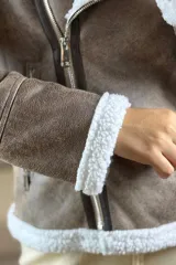 Campera tipo gamulán de cuero sintético negro con interior y solapas de corderito blanco. Presenta cierre frontal cruzado y bolsillos laterales con cierre.