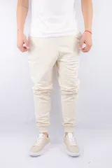 Pantalón de jogging color beige, de algodón, con cintura elástica y puños ajustados en los tobillos.