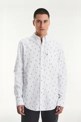 Camisa blanca de manga larga con estampado de piñas azules, cuello abotonado y bolsillo en el pecho con etiqueta roja de la marca Levi's.