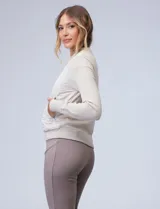 Campera bomber color beige, marca Elie Tahari. El frente es capitoneado con diseño de rombos, la espalda y las mangas son tejidas.