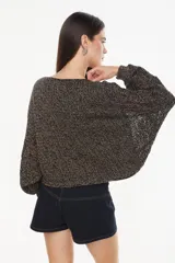 Sweater cropped de punto calado, color celeste melange, con mangas anchas de diseño holgado y cuello redondo.