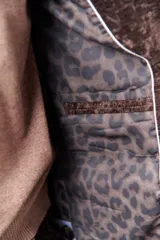 Blazer marrón de terciopelo con solapas de muesca, cierre frontal con un botón, bolsillos delanteros y forro con estampado animal print.
