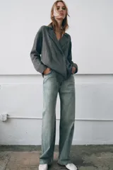 Camisa de corte oversize confeccionada en algodón, con estampado de cuadros pequeños en tonos grises. Presenta cuello solapa, cierre frontal con botones ocultos y mangas largas con puños rectos.