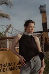 Top negro con cuello halter de puntilla blanca, sin mangas y espalda descubierta.