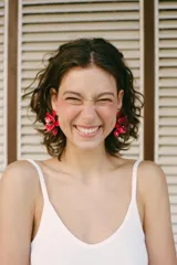 Maxi pendientes metálicos en forma de flor con pétalos rojos esmaltados y centro decorativo en color negro.