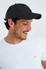 Gorro deportivo negro con perforaciones para ventilación y ajuste trasero con cinta.