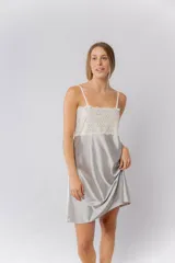 Camisón de satén elastizado color gris claro, con escote recto y detalle de puntilla elastizada en el busto y espalda. Tiene breteles finos regulables y un largo por encima de la rodilla.