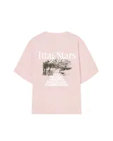 Remera rosa de corte holgado con estampado en la espalda de un paisaje con palmeras y el texto "Ittai Stars" y nombres de ciudades.