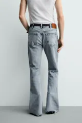 Jeans flare fit de tiro medio, confeccionados en denim de algodón color azul con efecto deslavado. Diseño ajustado en la parte superior y abierto en campana desde la rodilla, con cinco bolsillos y cierre frontal con cremallera y botón.