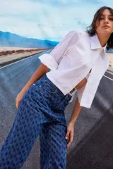 Jean de tiro bajo y corte oversize, confeccionado en denim azul con monograma grabado a láser en toda la prenda. Presenta doble botón metálico en la cintura y diseño de cinco bolsillos.