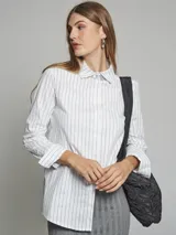 Camisa azul con rayas verticales blancas, de corte clásico, con cuello camisero y mangas largas.