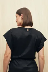 Top negro de tejido acanalado con acabado brillante, escote en V profundo, manga corta y frunce bajo el busto.