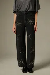 Pantalón de jean negro de corte ancho y tiro alto, decorado con aplicaciones de strass formando estrellas en toda la superficie.