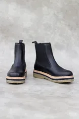 Bota Chelsea de cuero negro con elástico lateral, tirador trasero y suela track con detalle de vira color natural.