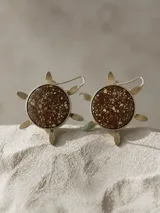 Aros colgantes con diseño circular en forma de sol, elaborados en plata esterlina con centro de piedra serpentina de tono marrón con incrustaciones moteadas.