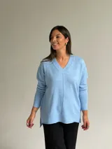 Sweater de punto color celeste, con cuello en V, mangas largas con puños acanalados y detalle de costura vertical central.