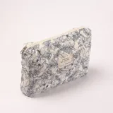 Necesér acolchado con estampado floral en azul sobre fondo blanco, cierre de cremallera y etiqueta con texto.