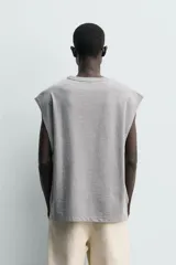 Camiseta sin mangas de corte relajado, color gris melange, con cuello redondo y estampa bordada en contraste en el frente.