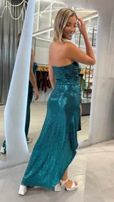 Vestido largo strapless de lentejuelas color verde esmeralda, con diseño ajustado y tajo lateral profundo.