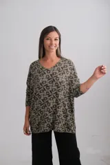 Sweter de punto con escote en V, manga larga y corte amplio. Presenta un estampado geométrico de mosaicos en tonos verdes y oscuros.