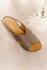 Sandalias doradas con tiras cruzadas y ajuste con hebilla.