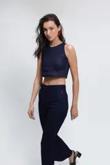 Pantalón de jean azul oscuro con corte semi oxford, pespuntes en color rojo y abertura en la parte inferior. Confeccionado en denim elastizado, presenta un diseño de tiro medio con cierre frontal y logo bordado en rojo en la cadera.