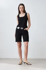 Bermuda de jean color negro, corte a la rodilla, con cinco bolsillos y presillas para cinturón.