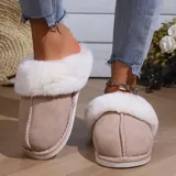 Pantufla cerrada de gamuza gris con interior y borde de peluche blanco, suela de goma antideslizante.