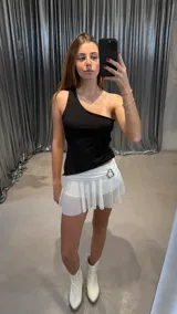 Top negro asimétrico de un hombro con corte irregular.