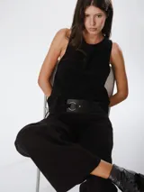 Chaleco de cuero marrón con diseño cruzado en la espalda y ajuste lateral mediante cordones. Presenta un corte holgado y moderno, ideal para usar como prenda de superposición.