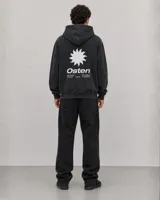 Canguro con capucha de color negro con efecto lavado, manga larga y bolsillo frontal tipo canguro. Presenta un pequeño estampado gráfico en el pecho con el logo de la marca.