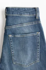 Jean de cinco bolsillos en denim de algodón con liviano stretch para una comodidad óptima, de corte ajustado en cintura y cadera, pierna bootcut y tiro alto con cierre y botón.