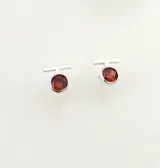 Aros pequeños de plata 950 con forma circular y detalle de piedra rosada.